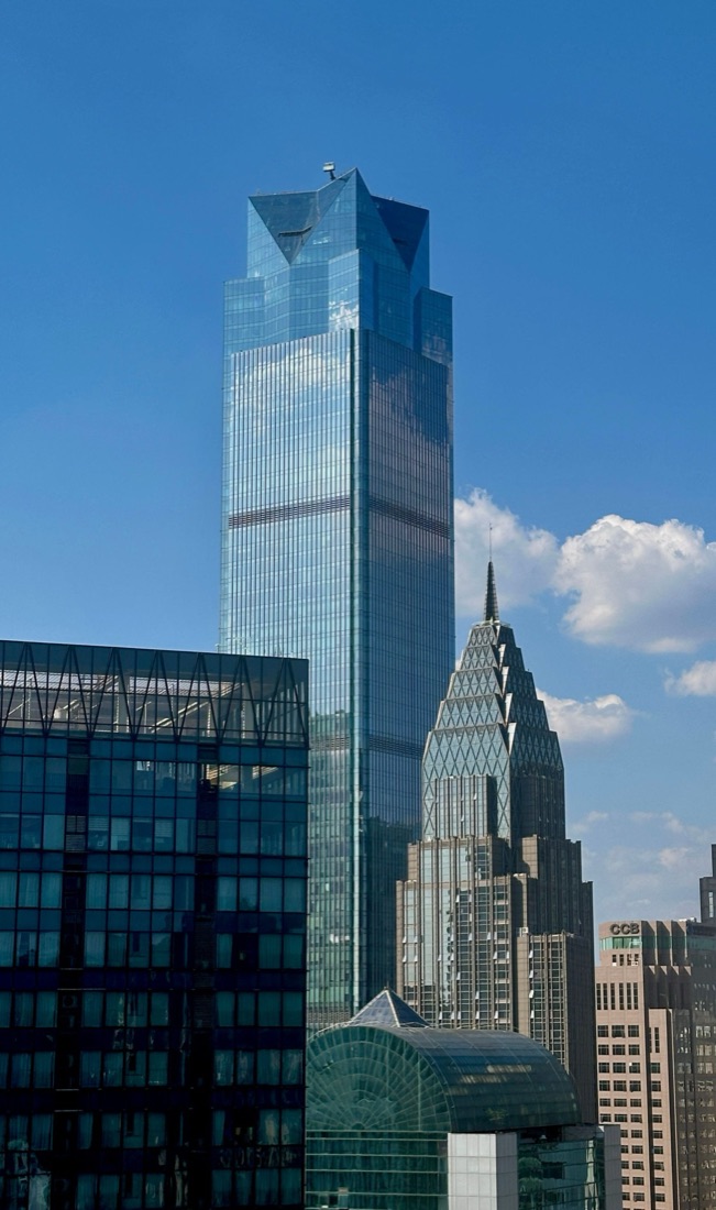 A glass skyscraper against a blue sky